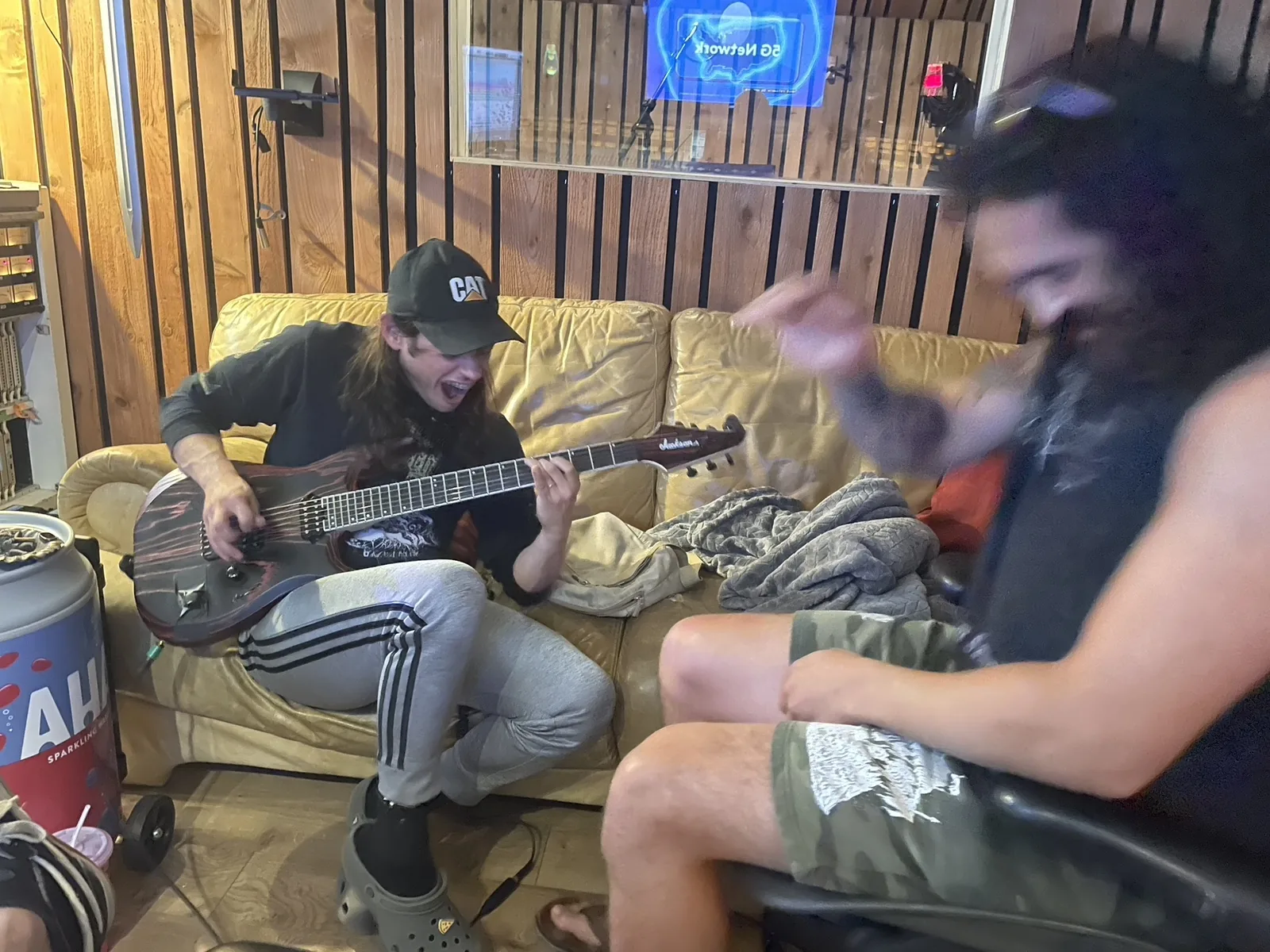Musicians playing bass and laughing on the studio couch