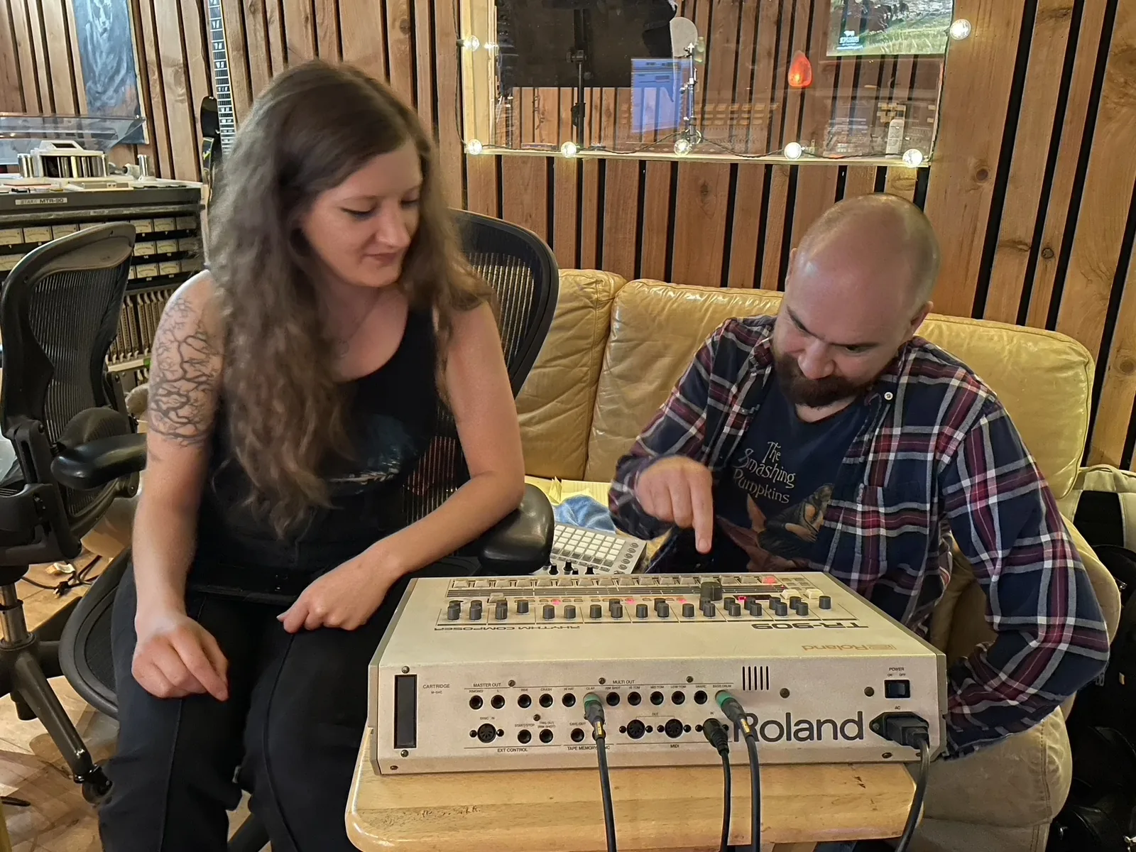 Two people working together over a Roland synthesizer
